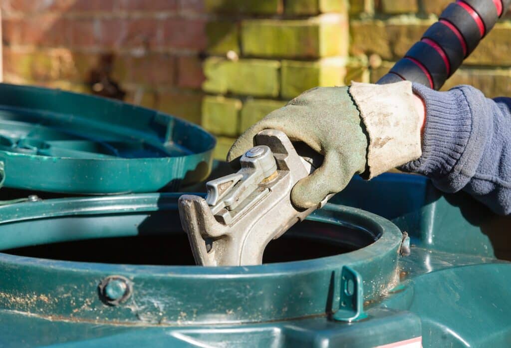 Closeup Of Man Filling A Bunded Oil Tank With Domestic Heating O